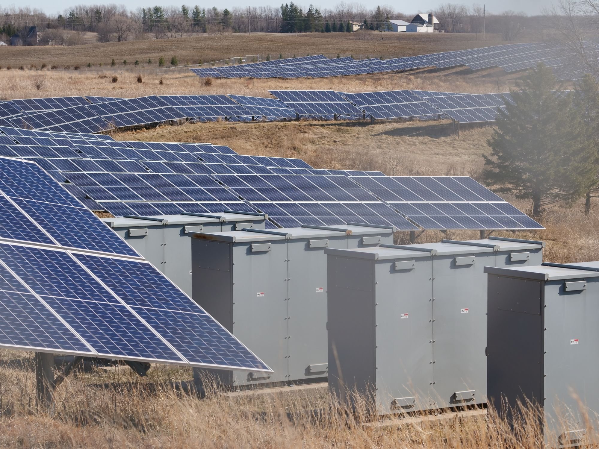 Rows of solar panels across an open rural landscape